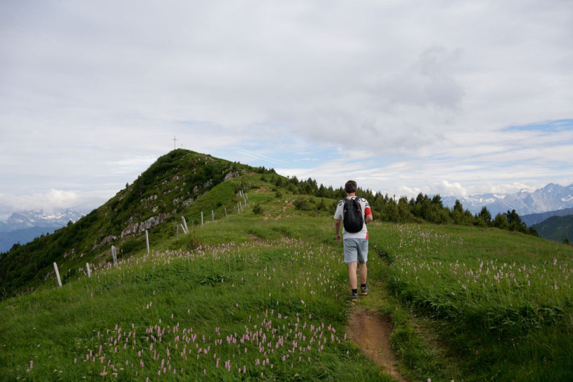 Wanderer mit leichtem Rucksack auf Alpenwiese